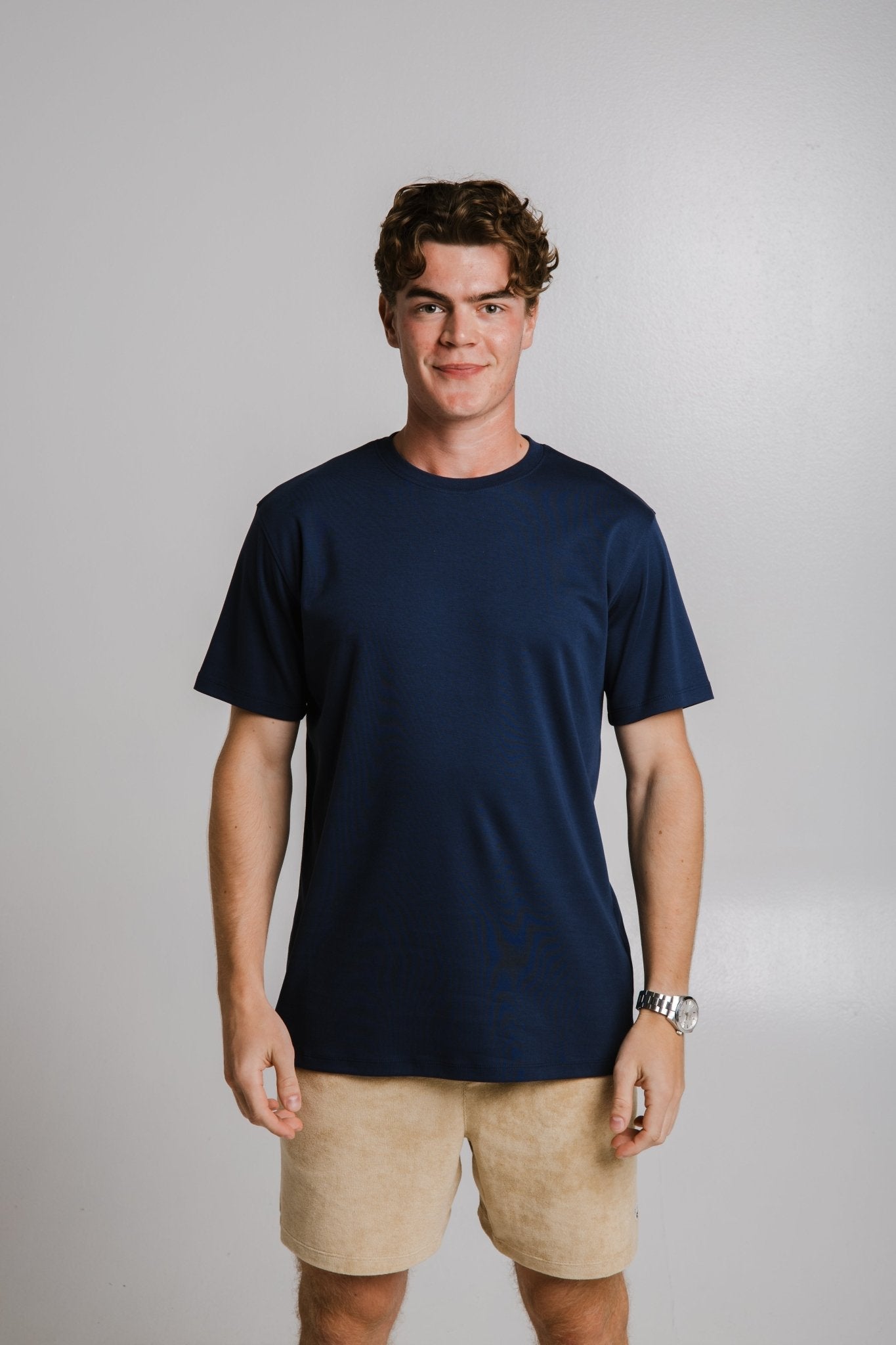 Sossu heavy tshirt dark blue worn by a man with beige shorts in a studio