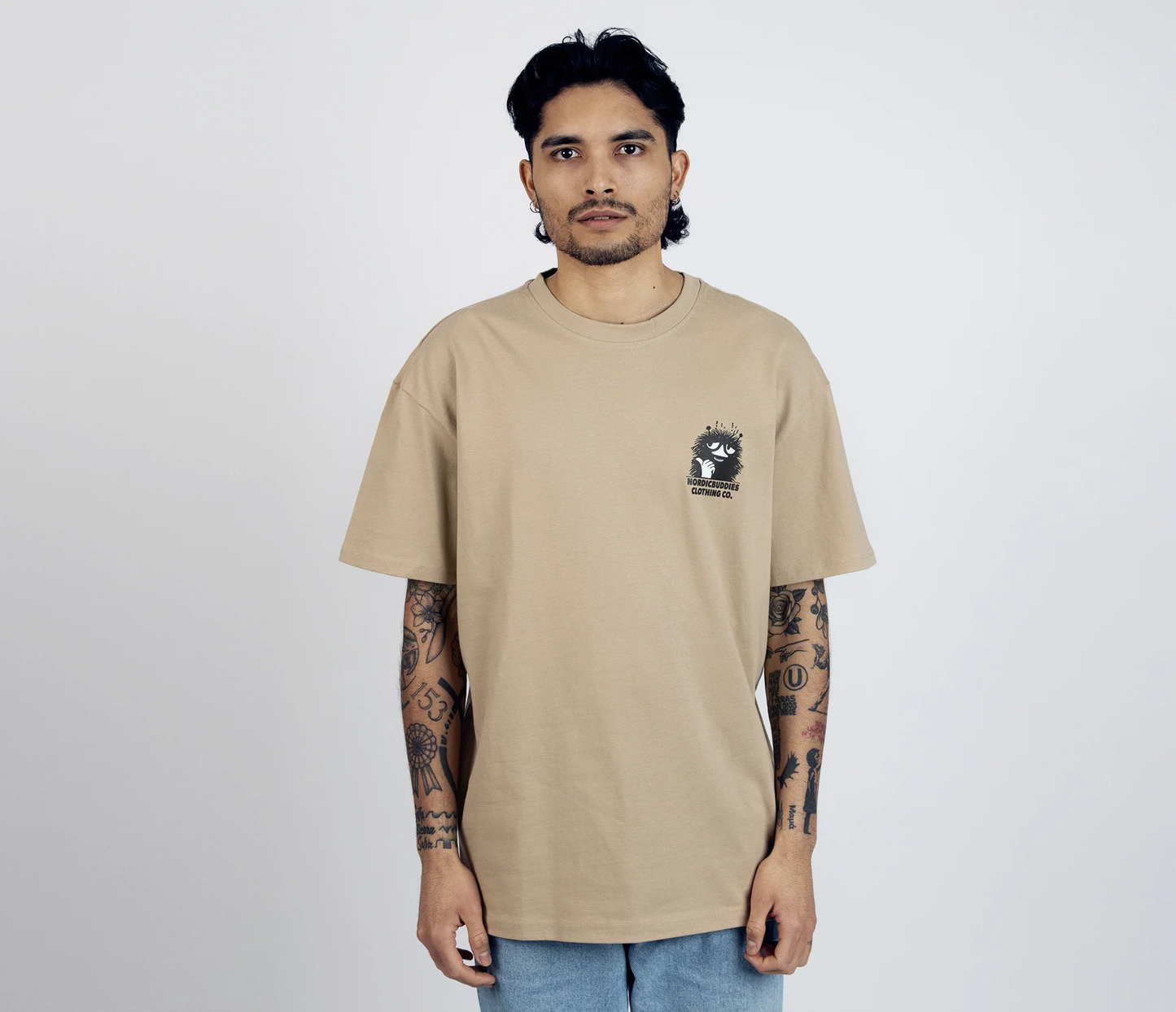 Man wearing Stinky Plotting T-Shirt Beige by Moomin with small graphic print on chest