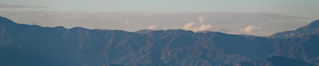 Panoramic mountain range at sunrise with layered blue ridges and sky suggesting outdoor cleaning gear Maitenance tips guide