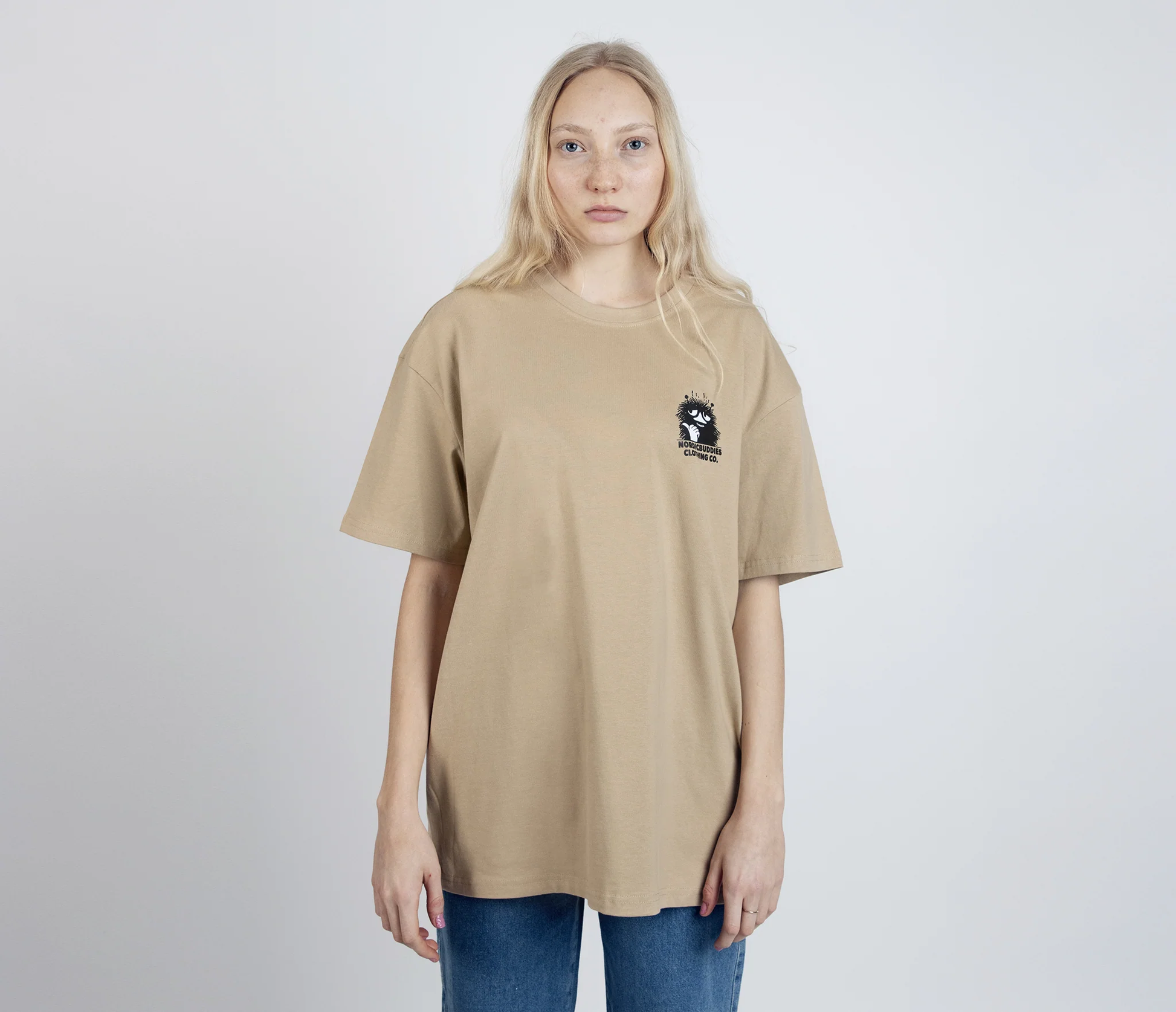 Stinky Plotting T-Shirt Beige by Moomin featuring small graphic on front worn by model with long blonde hair
