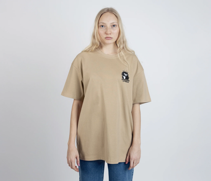Stinky Plotting T-Shirt Beige by Moomin featuring small graphic on front worn by model with long blonde hair